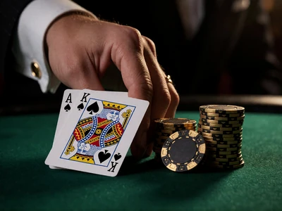 Blackjack-Hand mit Ass und K&ouml;nig auf gr&uuml;nem Filz neben goldenen Chips im High-Limit-Bereich